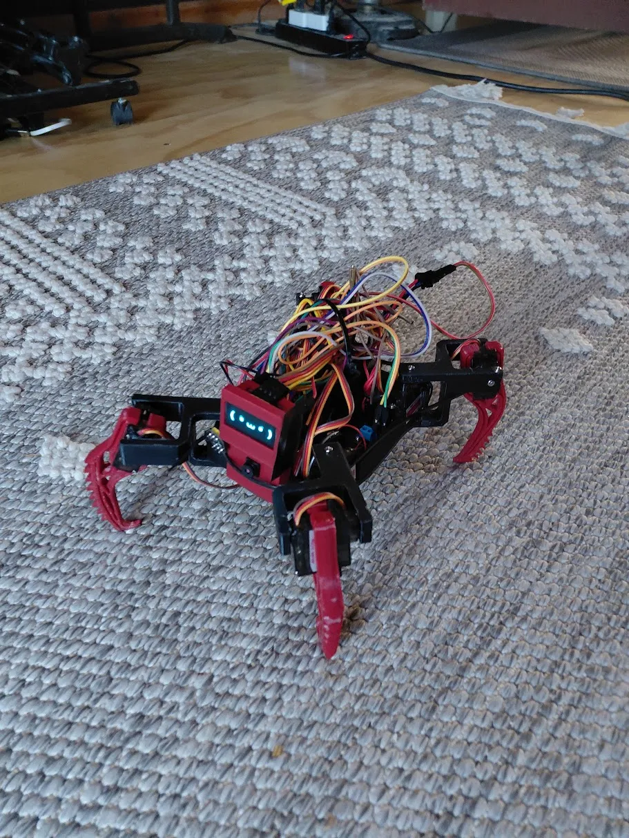 The early red printed robot on the carpet, with its mechanisms and wiring visible.