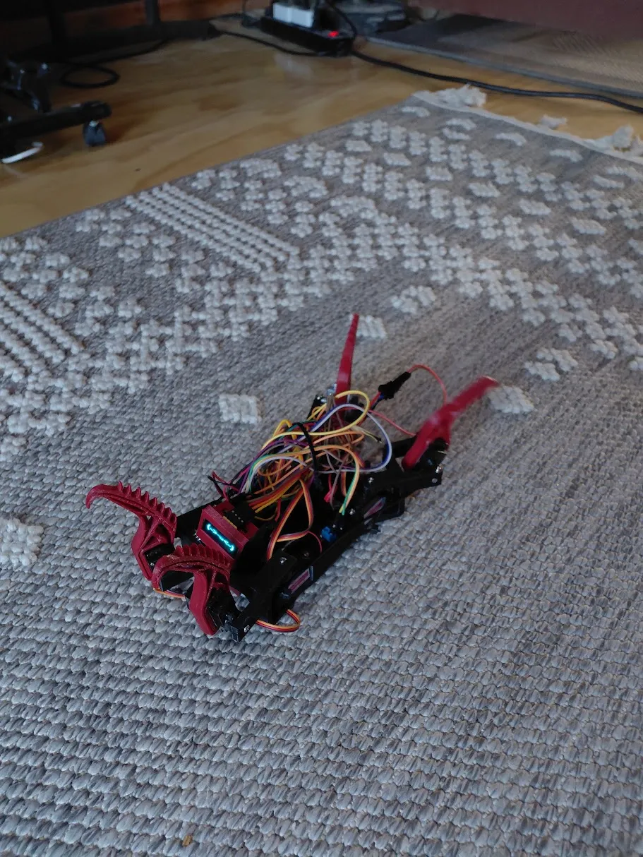 The early red printed robot on the carpet, with its mechanisms and wiring visible.