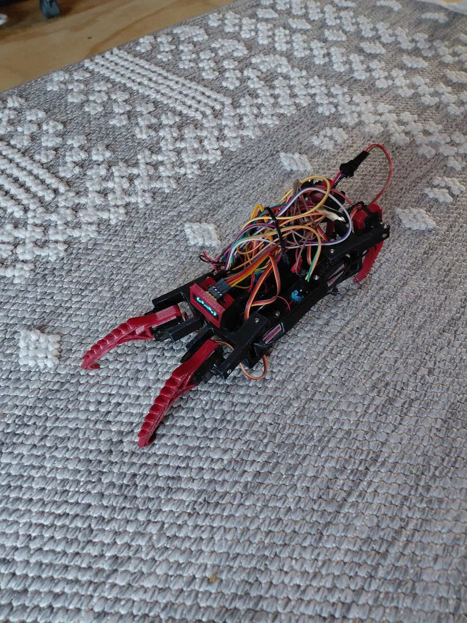The early red printed robot on the carpet, with its mechanisms and wiring visible.