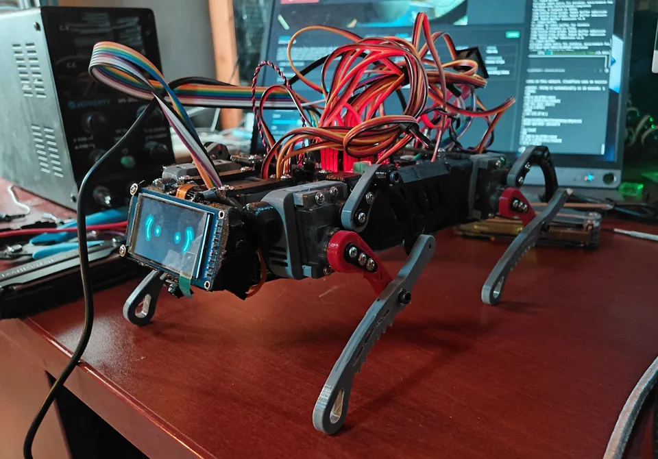 The uncovered twelve-servo prototype on the bench, with its illuminated face and exposed wiring.